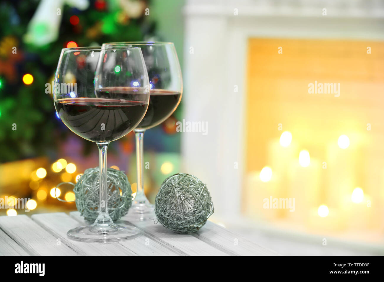 Two Wine Glasses With Christmas Decor On Fireplace Background