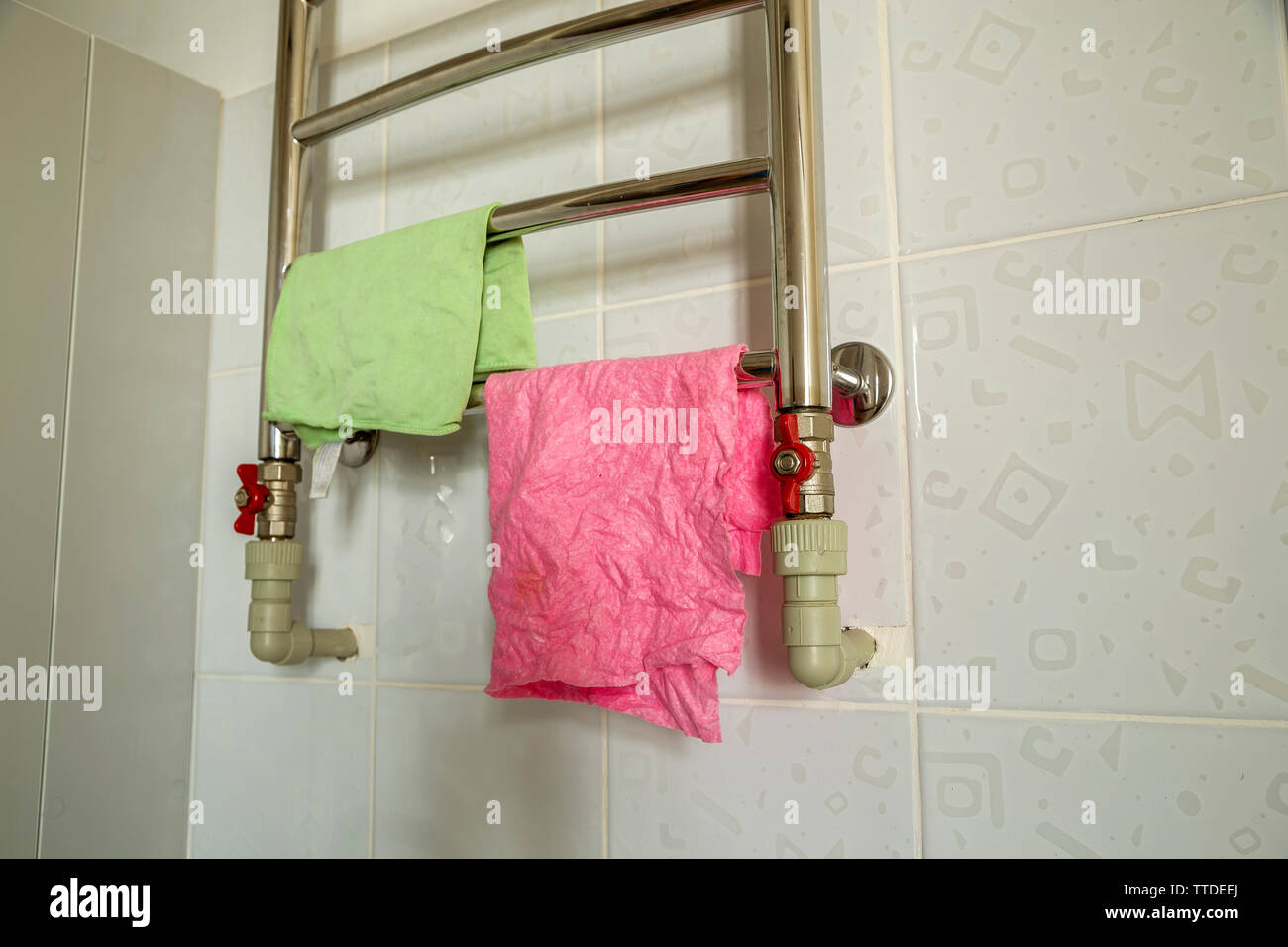 Pieces of cloth drying on bathroom heating towel rail radiator. Towel