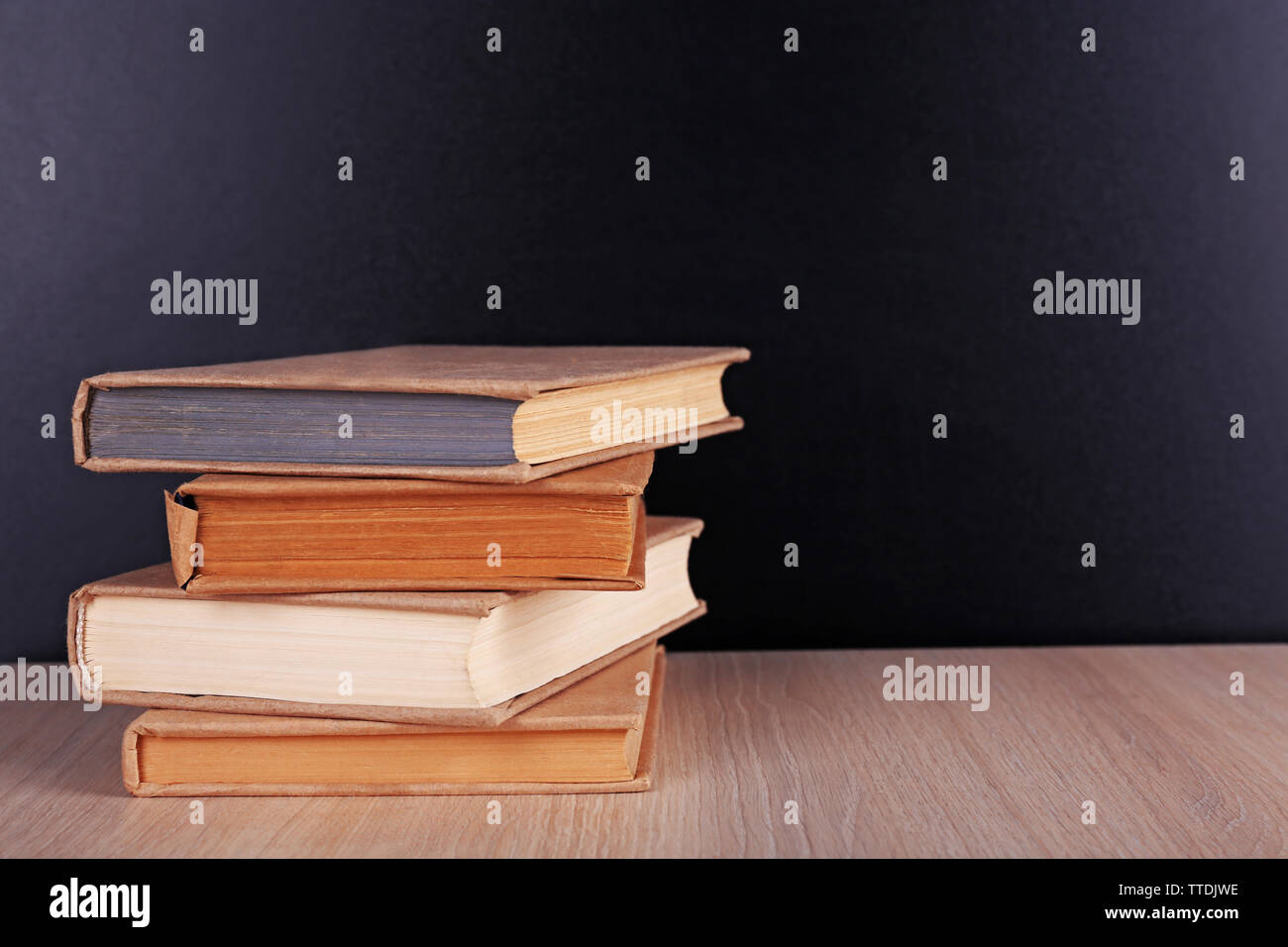 Book Behind Table Books on a table on blackboard background Stock Photo - Alamy
