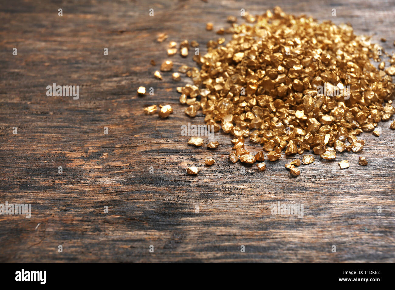 A pile of Gold nugget grains, on wooden background Stock Photo - Alamy