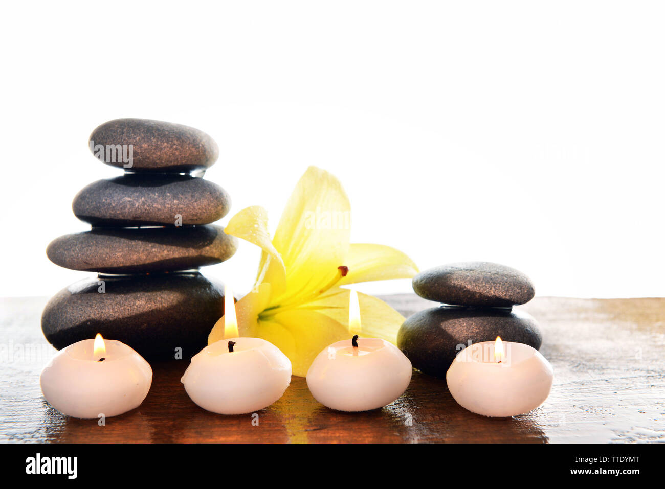 Spa stones with candles and lily, isolated on white Stock Photo - Alamy