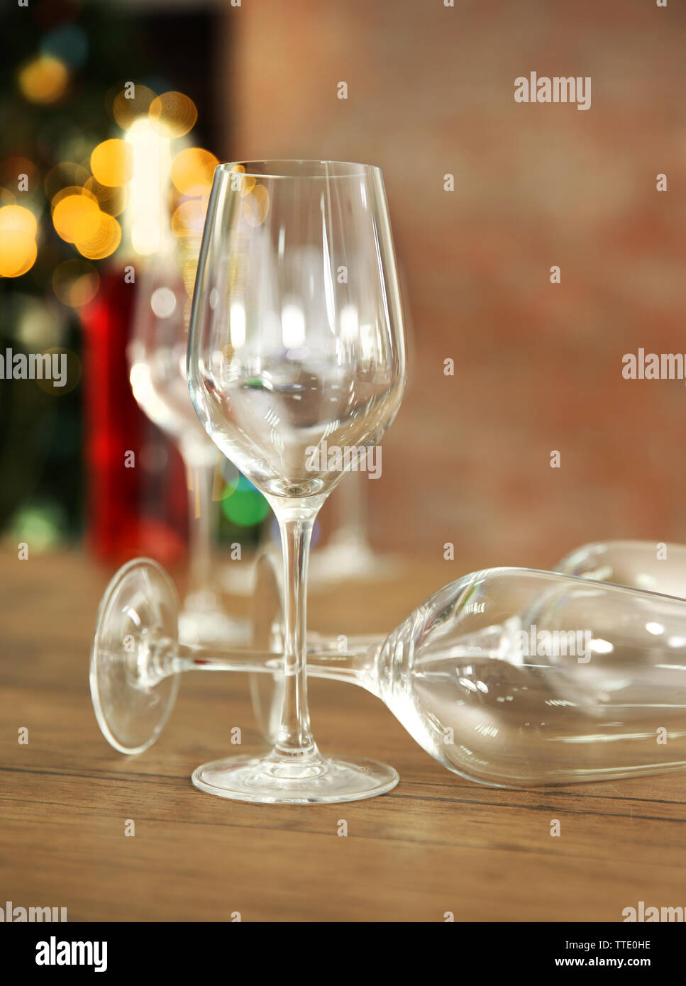 Empty wine glasses with bottle on wooden table against blurred background Stock Photo