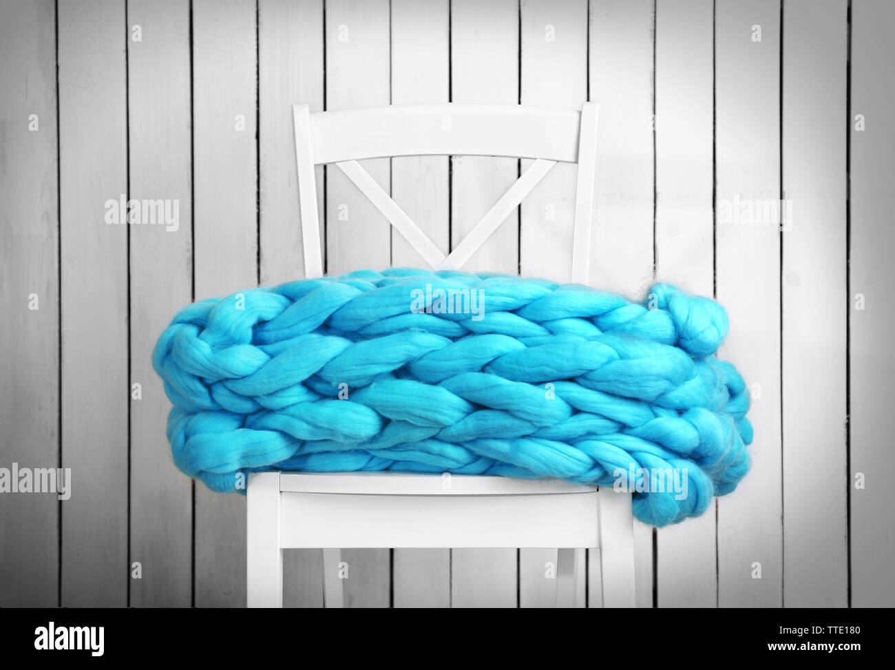 Knitted woolen blanket on chair, on home interior background Stock