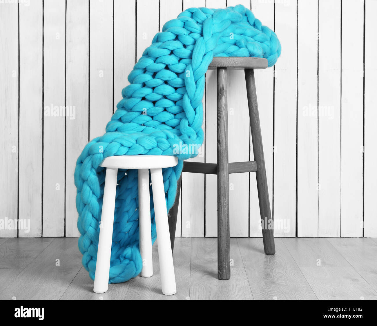Knitted woolen blanket on chair, on home interior background Stock