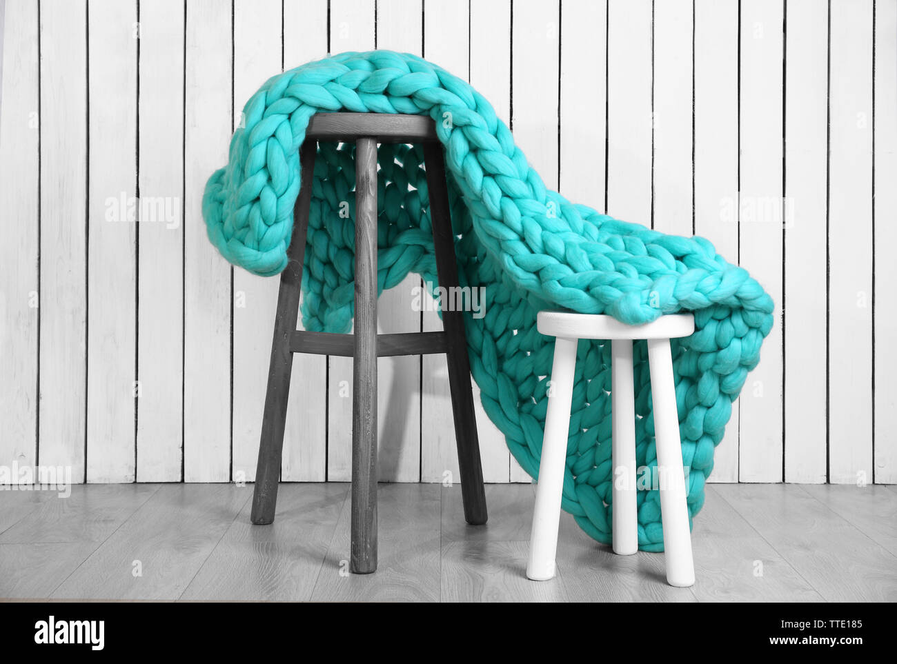 Knitted woolen blanket on chair, on home interior background Stock