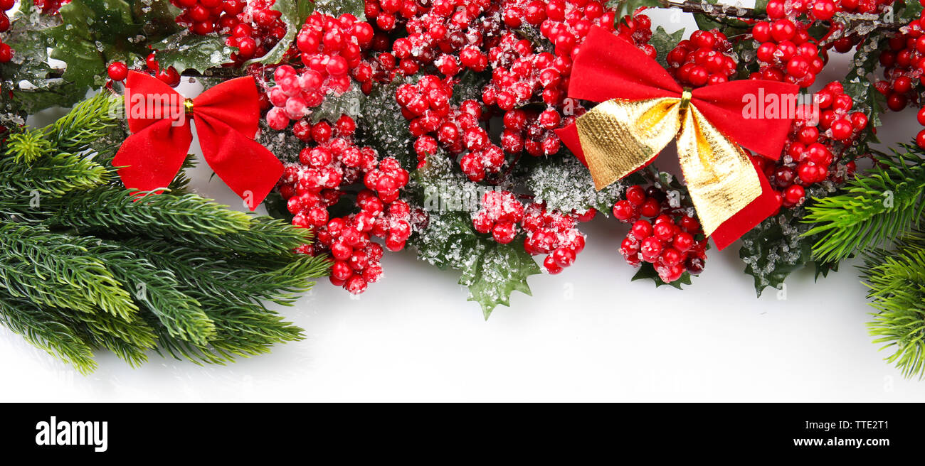 Christmas tree branch with red berries and bows on white background ...