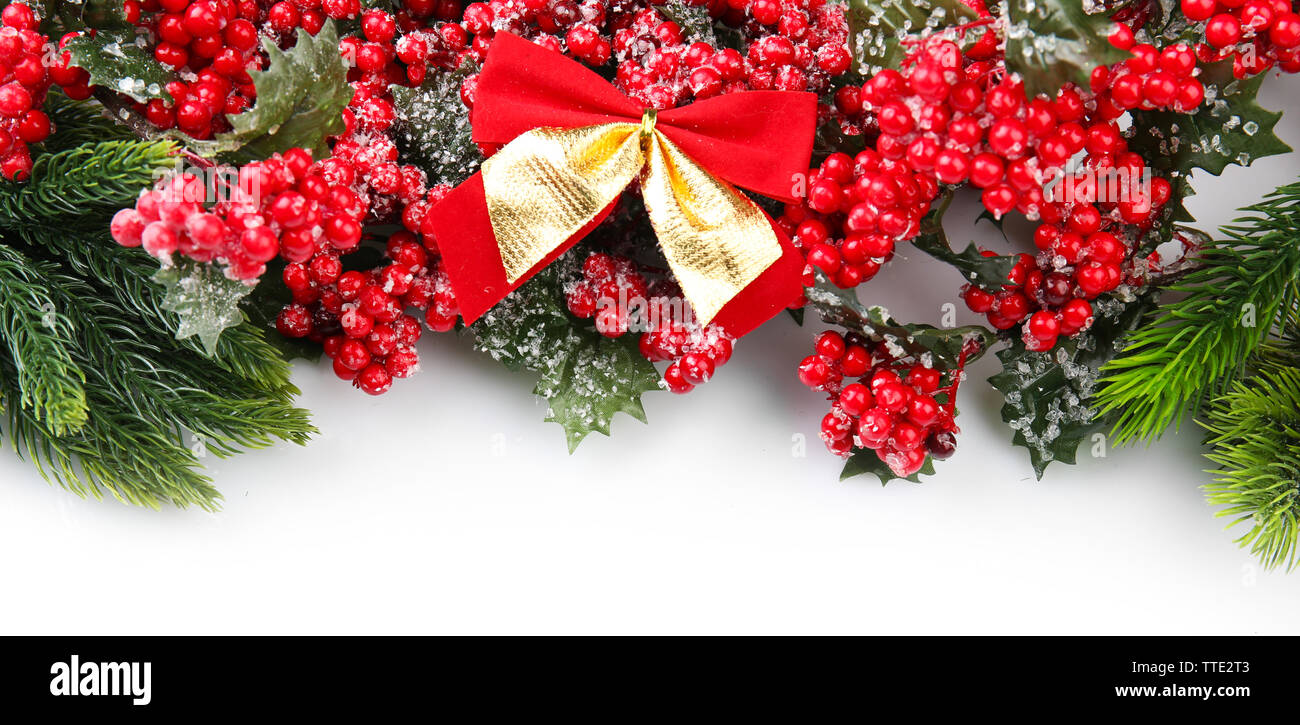 Christmas tree branch with red berries and bows on white background ...