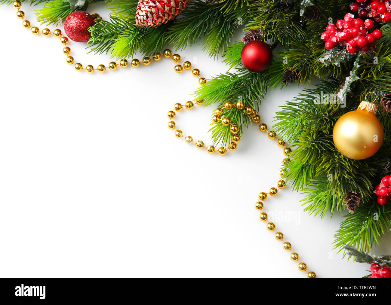 Christmas tree branch with red berries and decorations on white ...