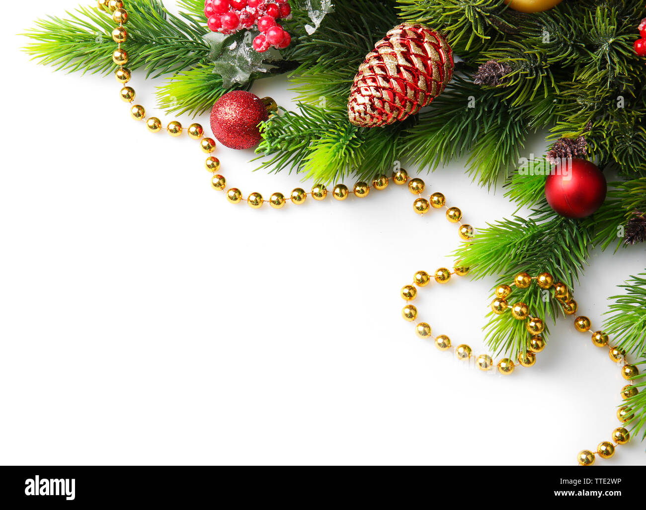 Christmas tree branch with red berries and decorations on white ...