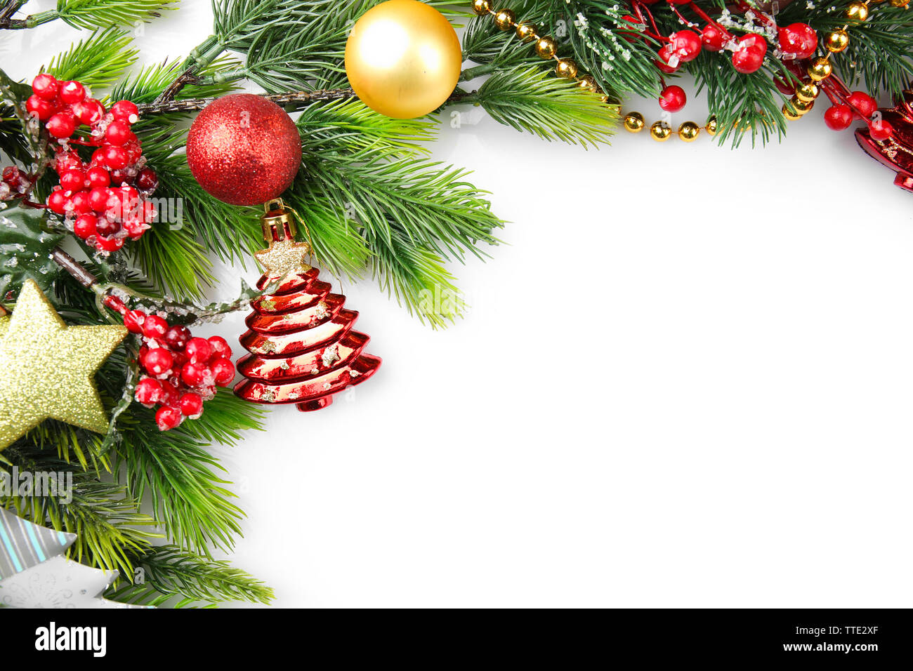 Christmas tree branch with red berries and decorations on white ...