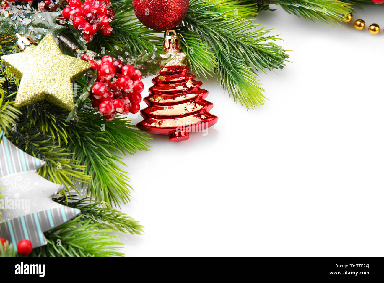 Christmas tree branch with red berries and decorations on white ...