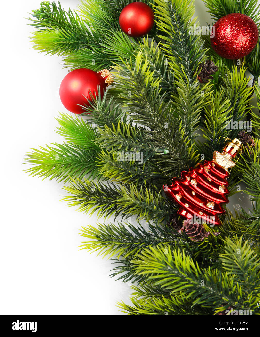 Christmas tree branch with red berries and decorations on white ...
