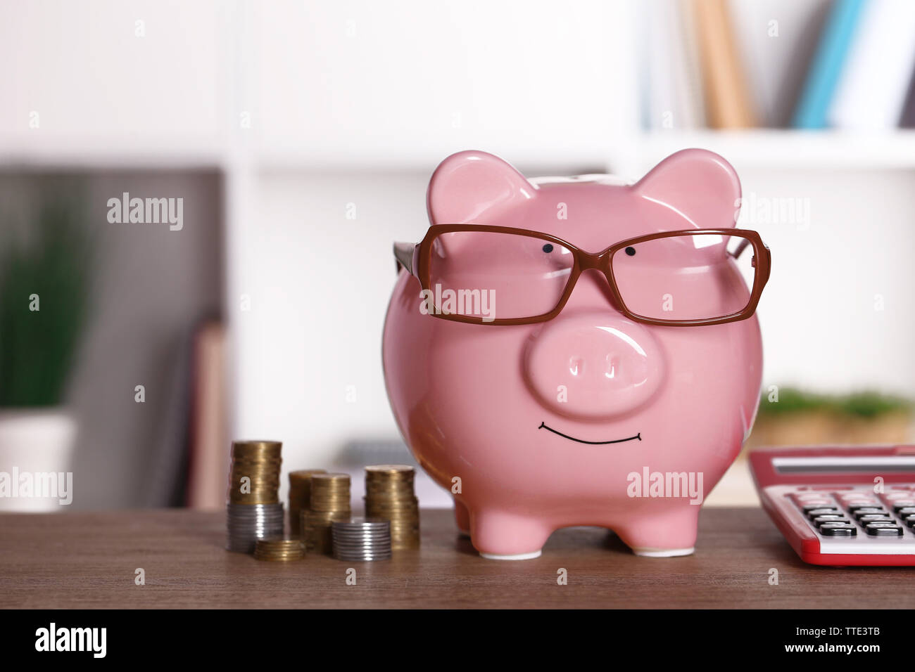 Piggy bank in glasses with calculator and coins on home or office ...