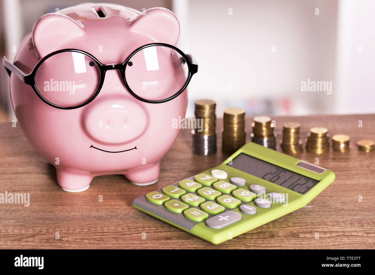 Piggy bank in glasses with calculator and coins on home or office ...