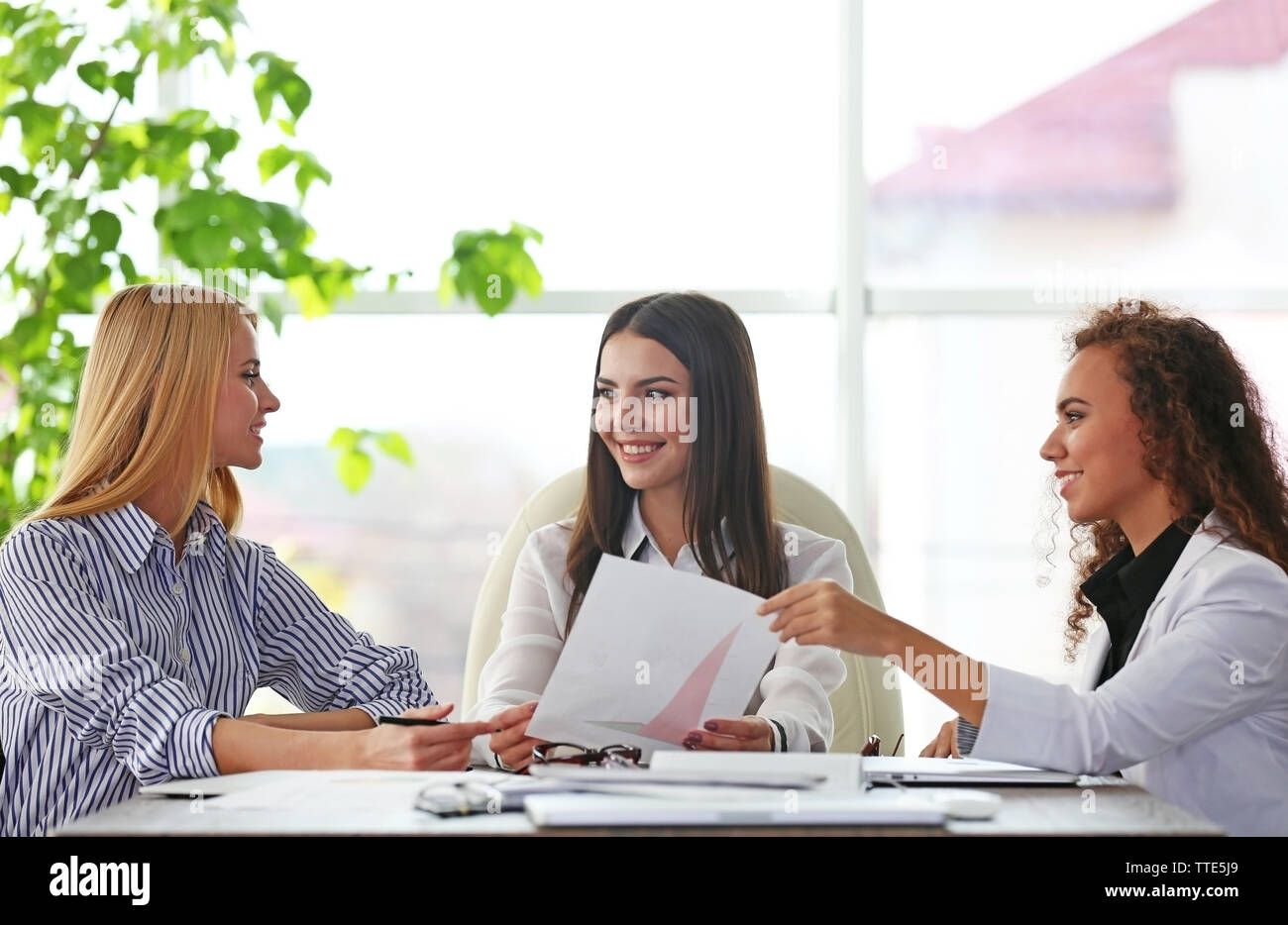 Three young businesswomen at the meeting in a conference room Stock ...