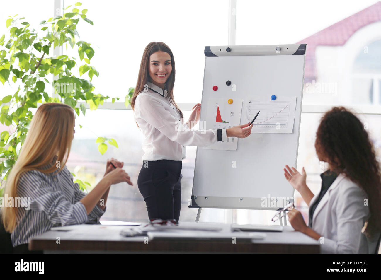 Three young businesswomen at the meeting in a conference room Stock ...