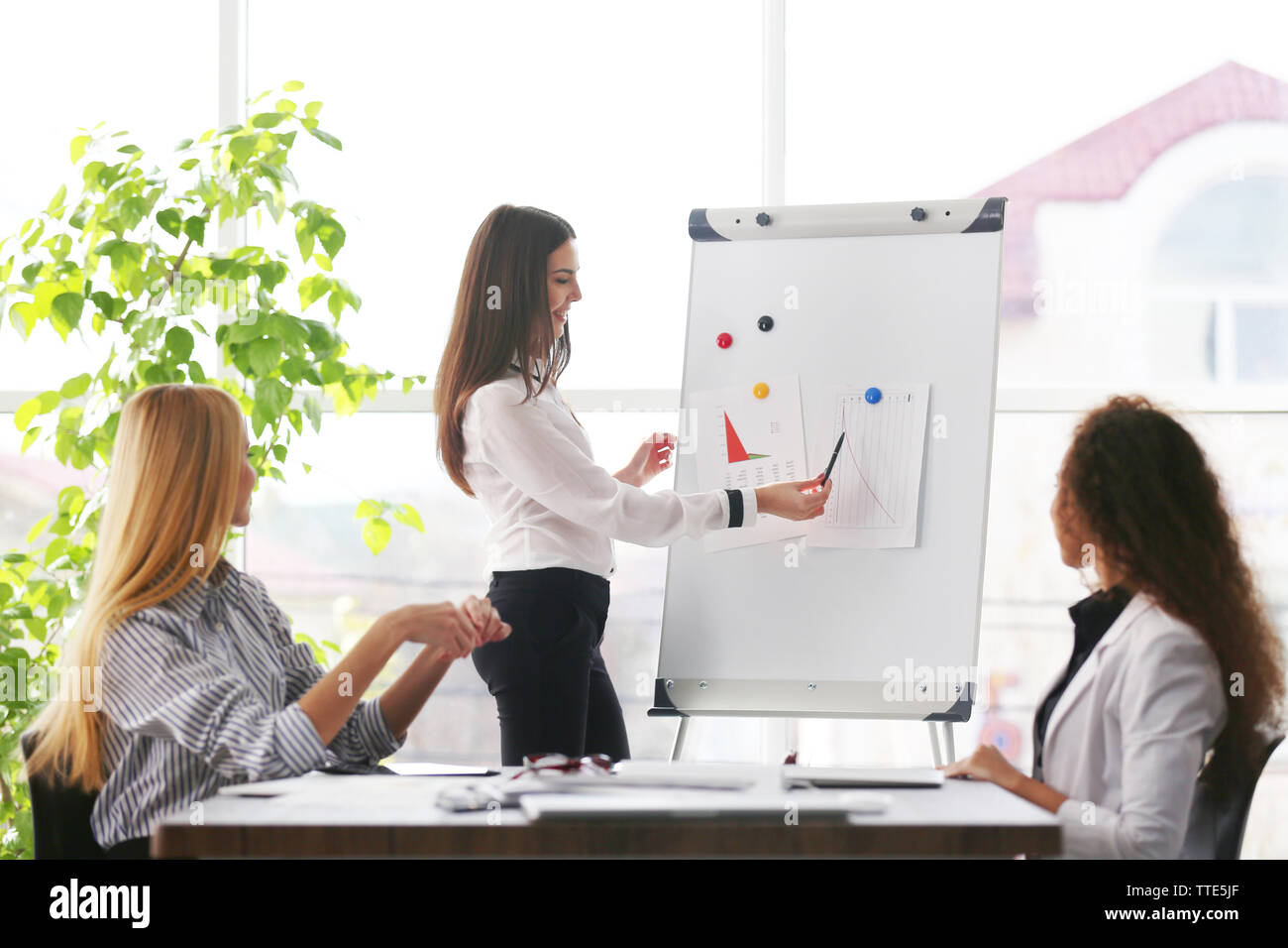 Three young businesswomen at the meeting in a conference room Stock ...