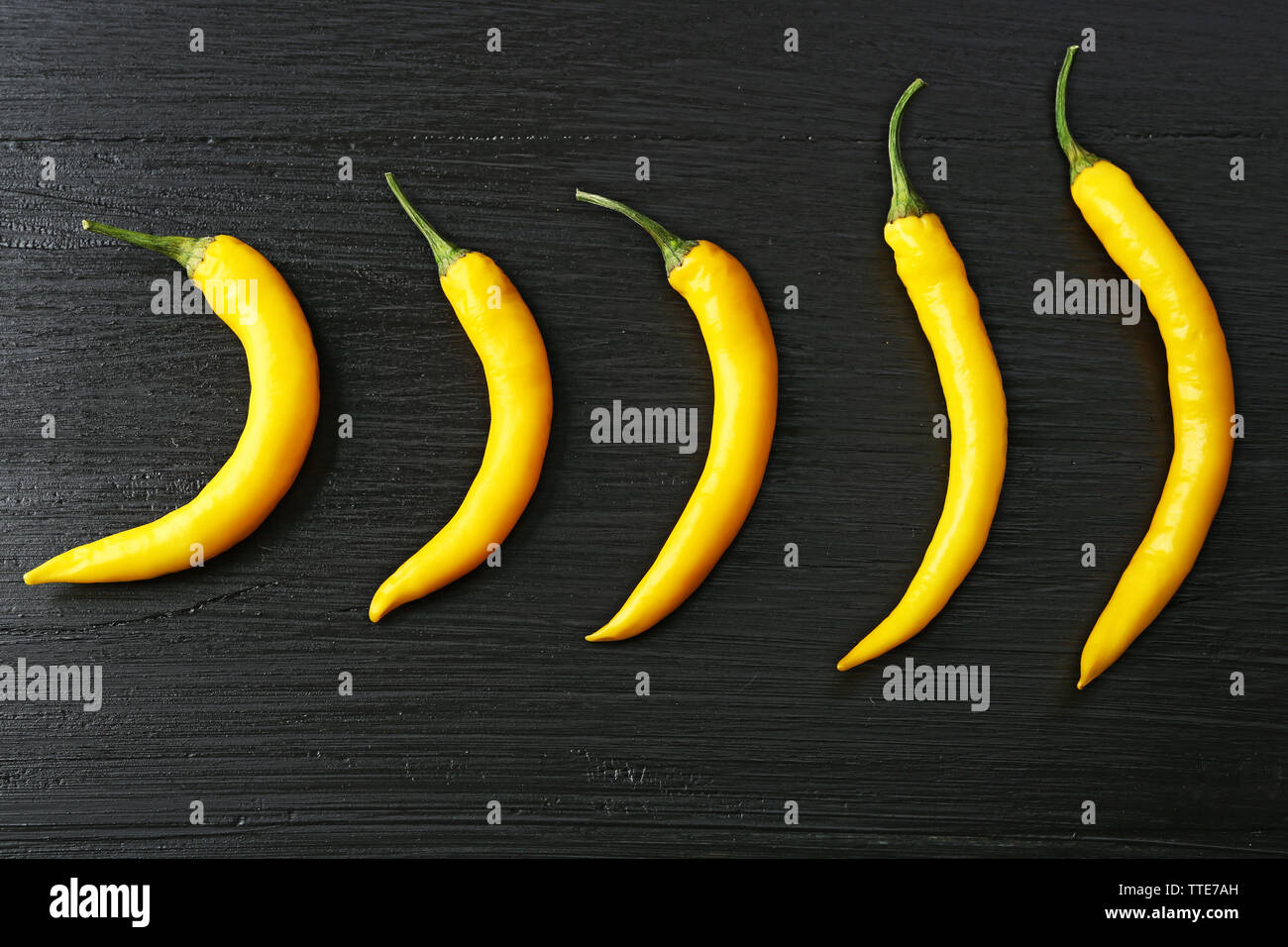 Yellow chili peppers on dark wooden background Stock Photo - Alamy