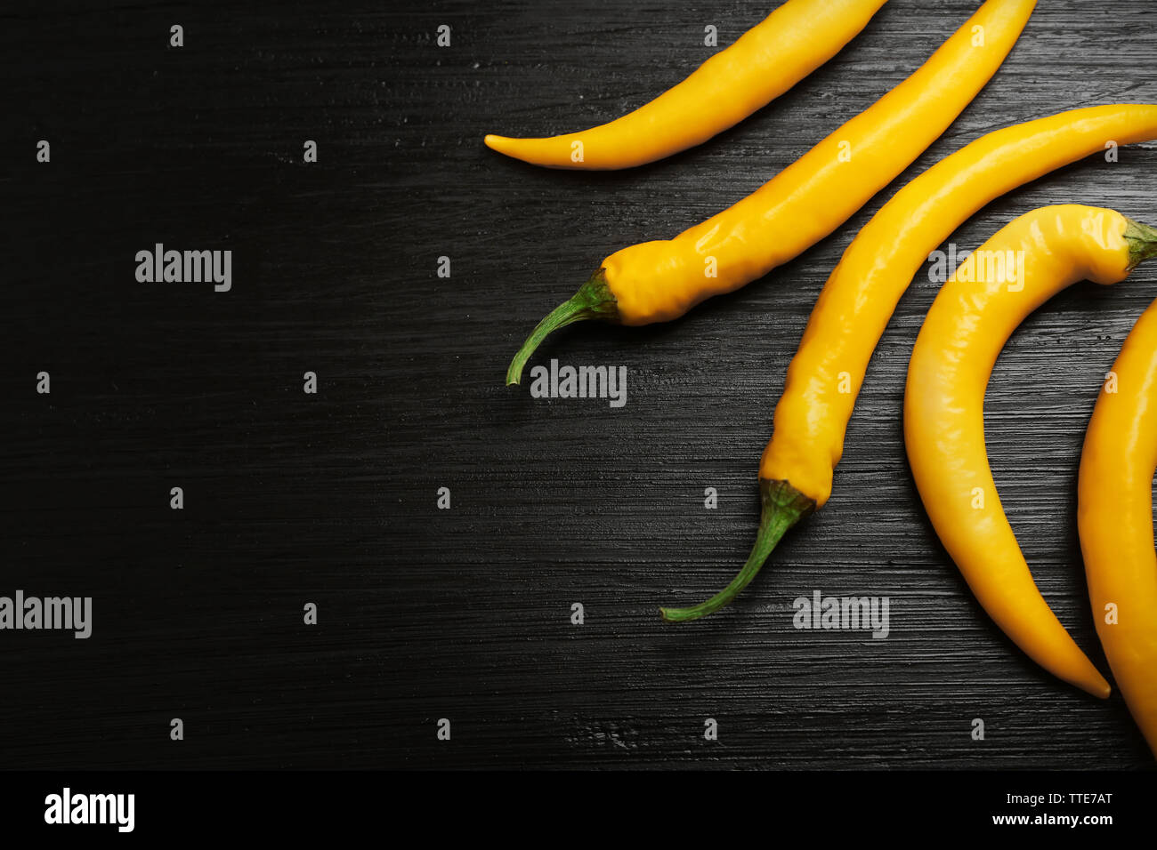 Yellow chili peppers on dark wooden background Stock Photo - Alamy