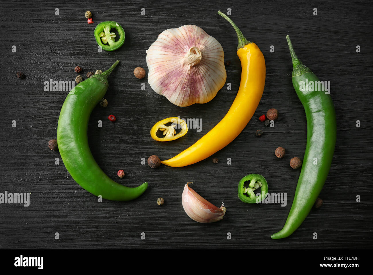 Garlic, green and yellow chili peppers on dark wooden background Stock ...