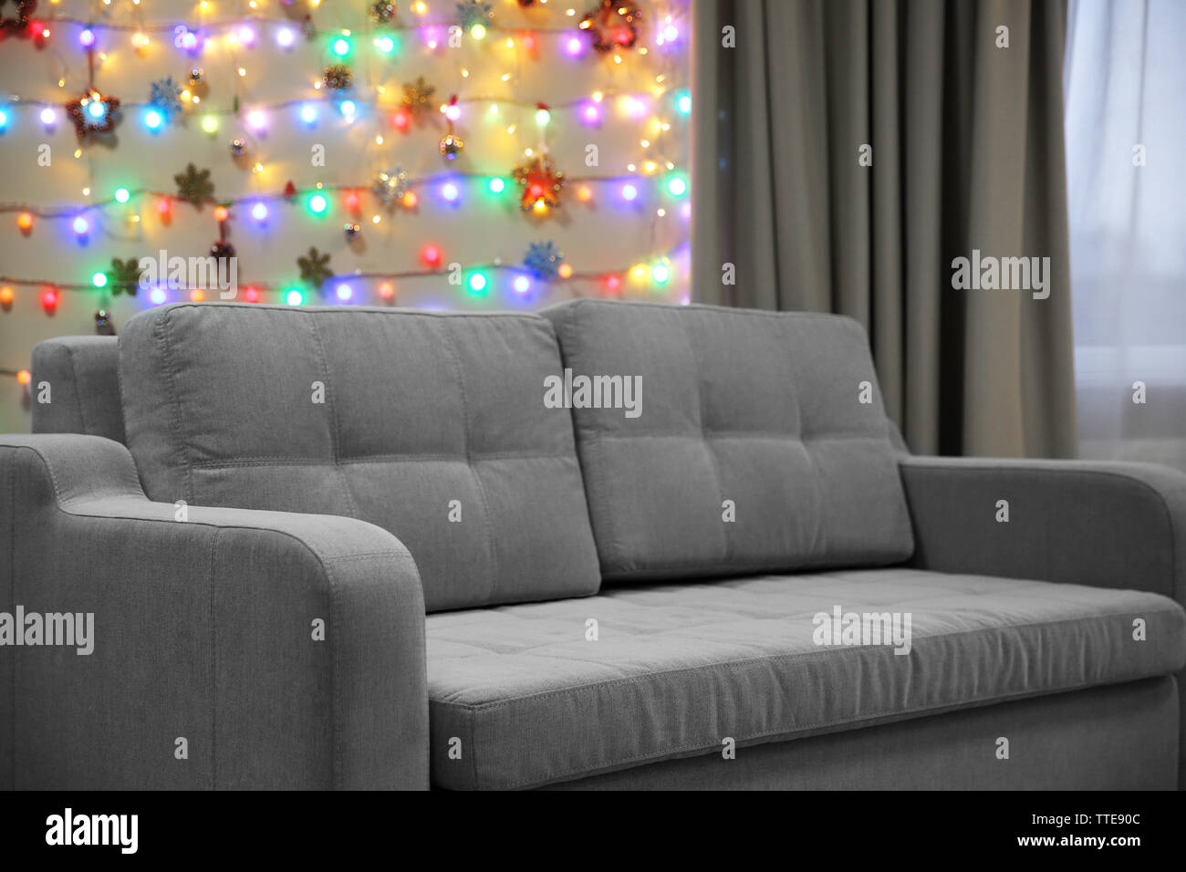 Grey couch on Christmas lights background Stock Photo Alamy