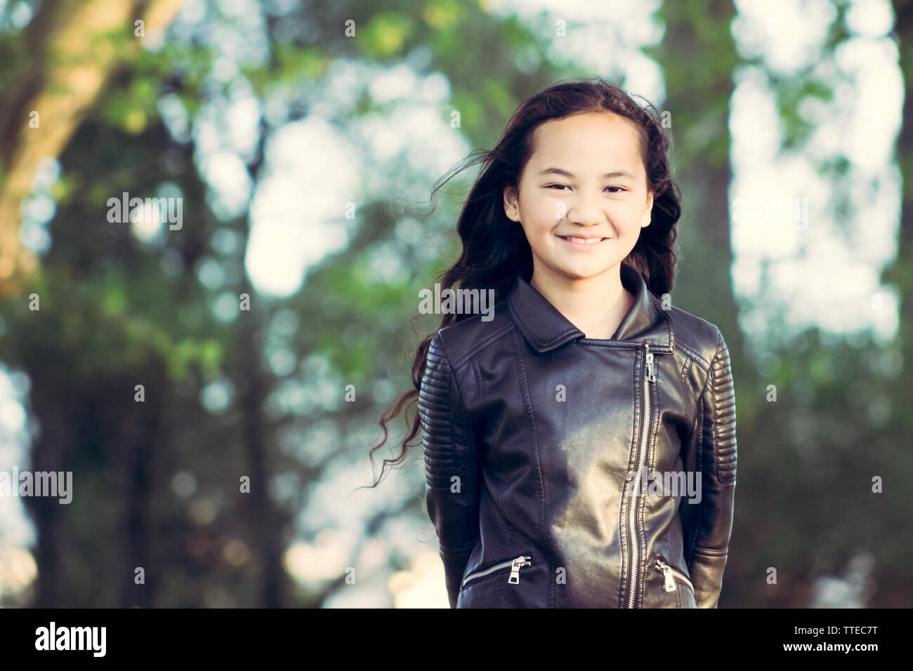 Portrait image of a young Maori girl taken outdoors in a park with copy space Stock Photo