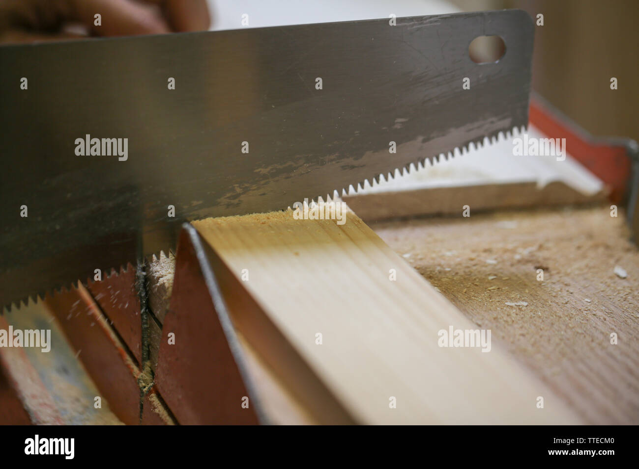 person sawing the wooden plank edge in a factory - Image Stock Photo