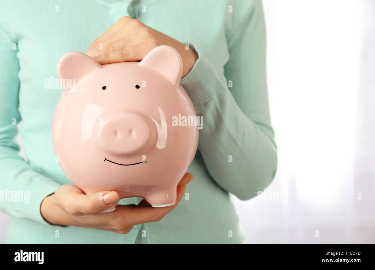 Woman holding piggy bank in hand. Financial savings concept Stock Photo ...