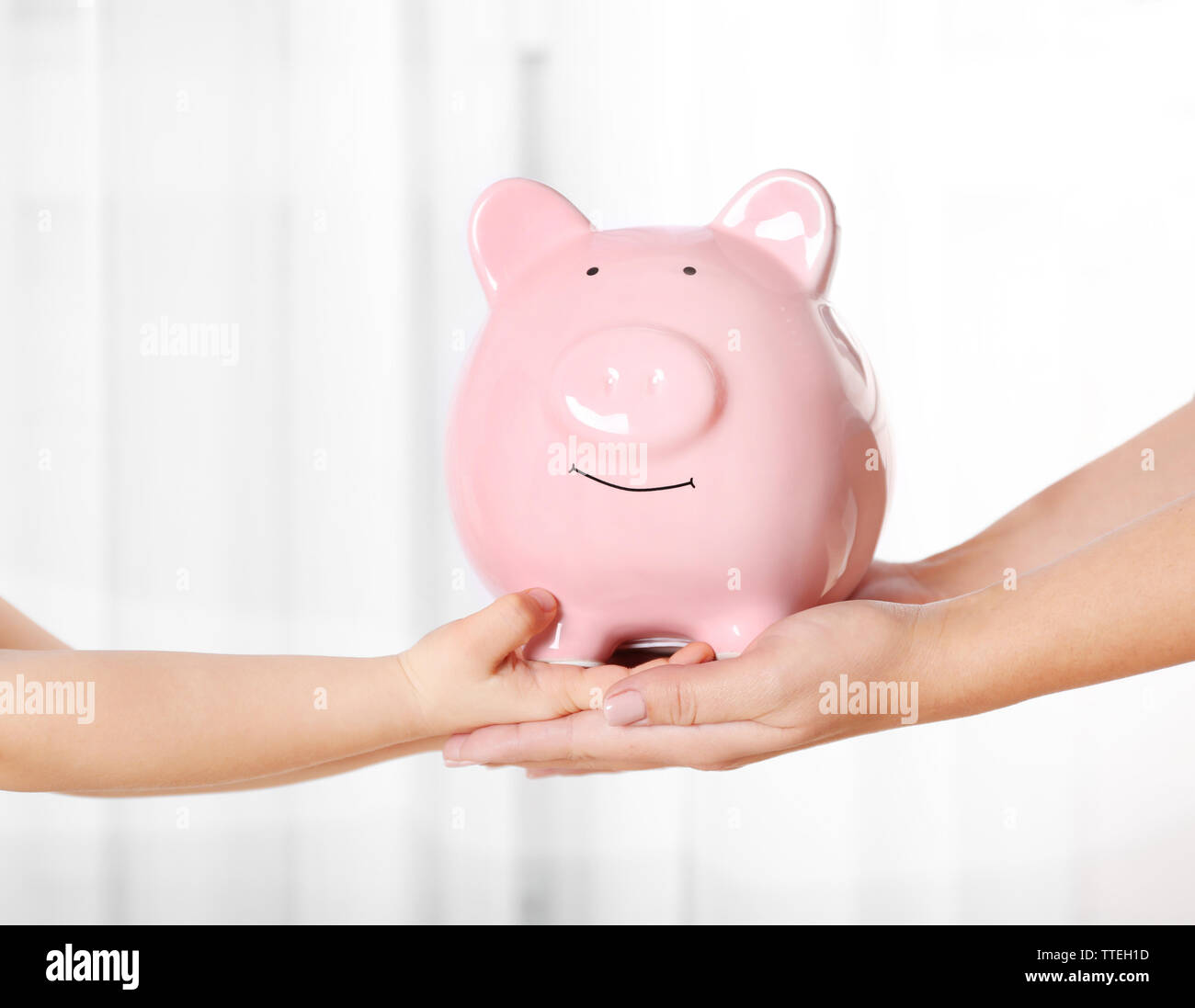 Savings concept. Piggy bank in parent and child hands Stock Photo - Alamy