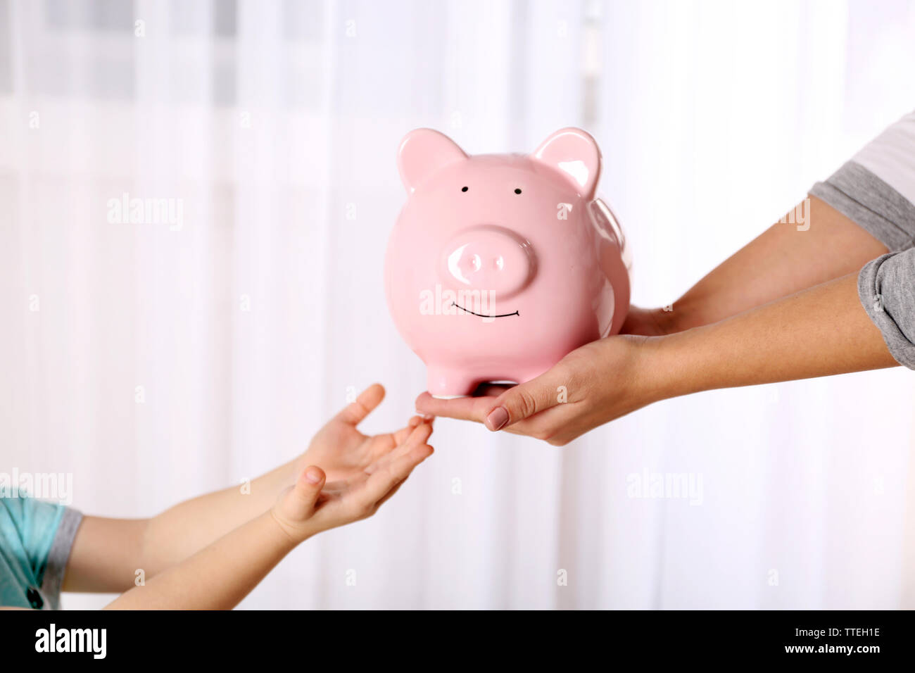 Savings concept. Piggy bank in parent and child hands Stock Photo - Alamy