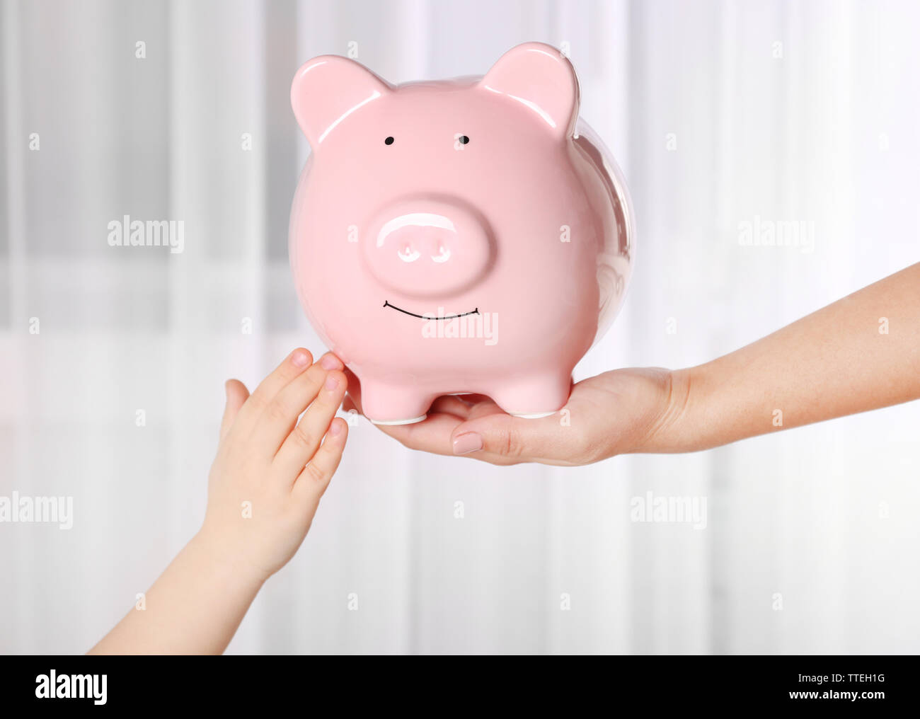 Savings concept. Piggy bank in parent and child hands Stock Photo - Alamy