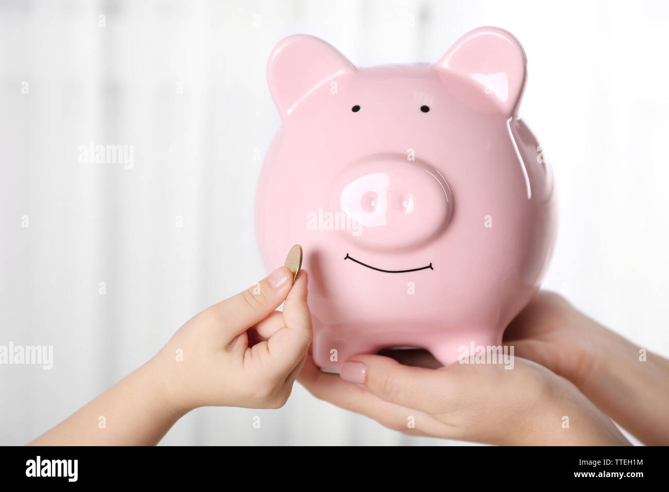 Savings concept. Piggy bank in parent and child hands Stock Photo - Alamy