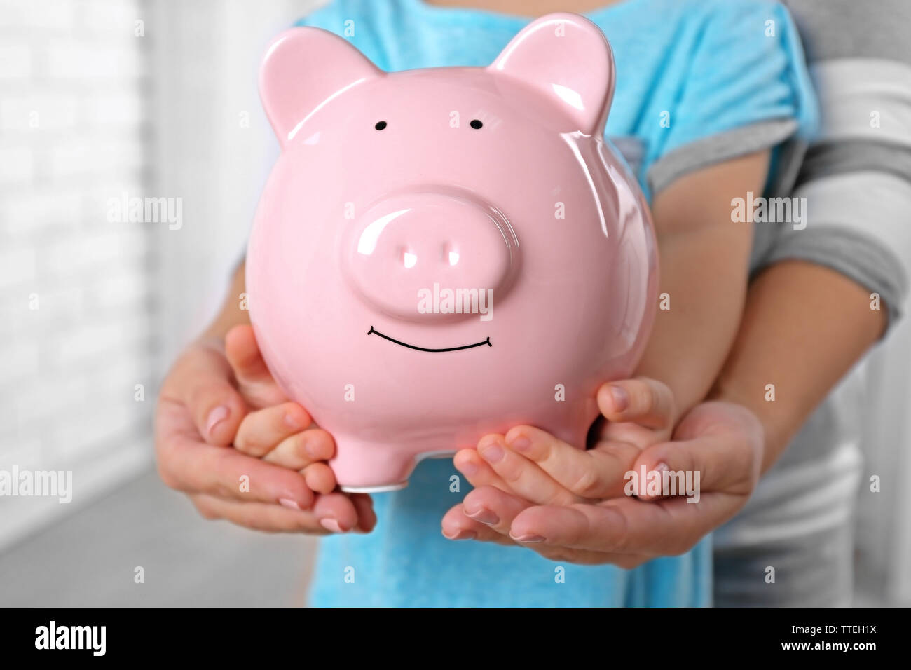 Savings concept. Hands holding piggy bank, close up Stock Photo - Alamy