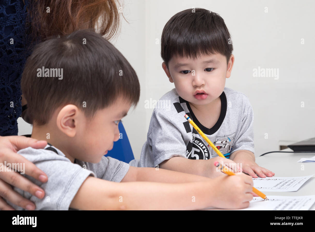 Manila, Philippines - August, 18, 2016: Two little boys learning to write with a pencil in classroom at school Stock Photo