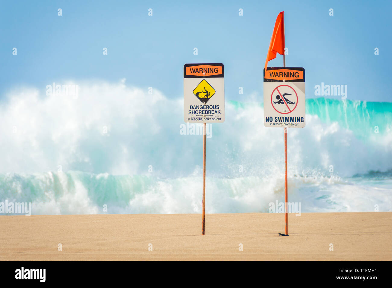 Warning signs indicating no swimming allowed due to huge waves and