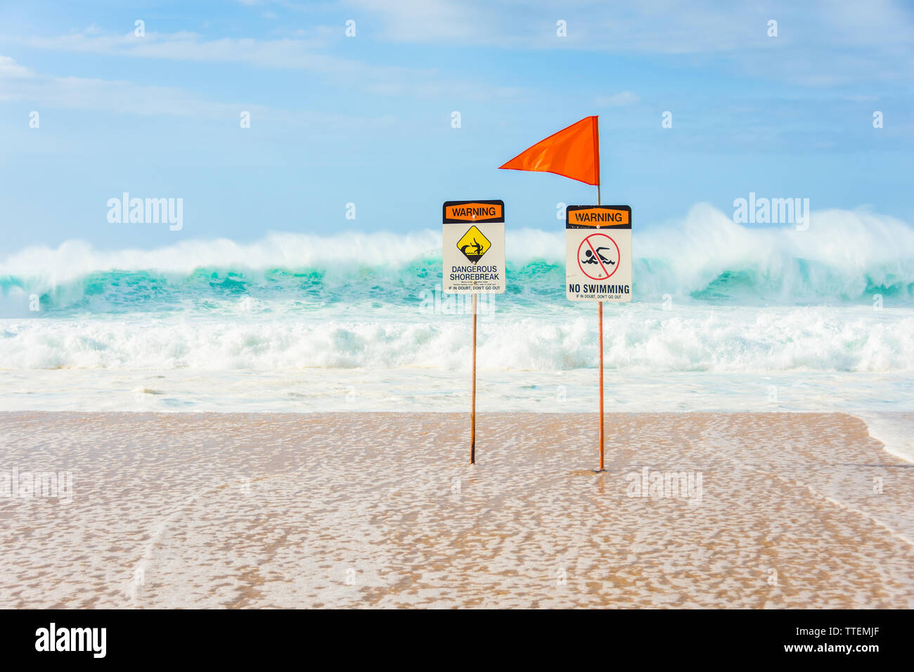 Warning signs indicating no swimming allowed due to huge waves and