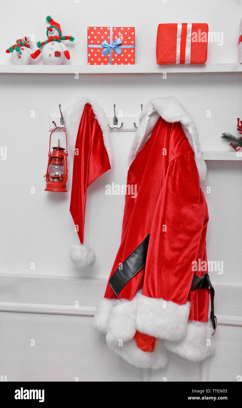 Santa costume hanging on white wall background Stock Photo
