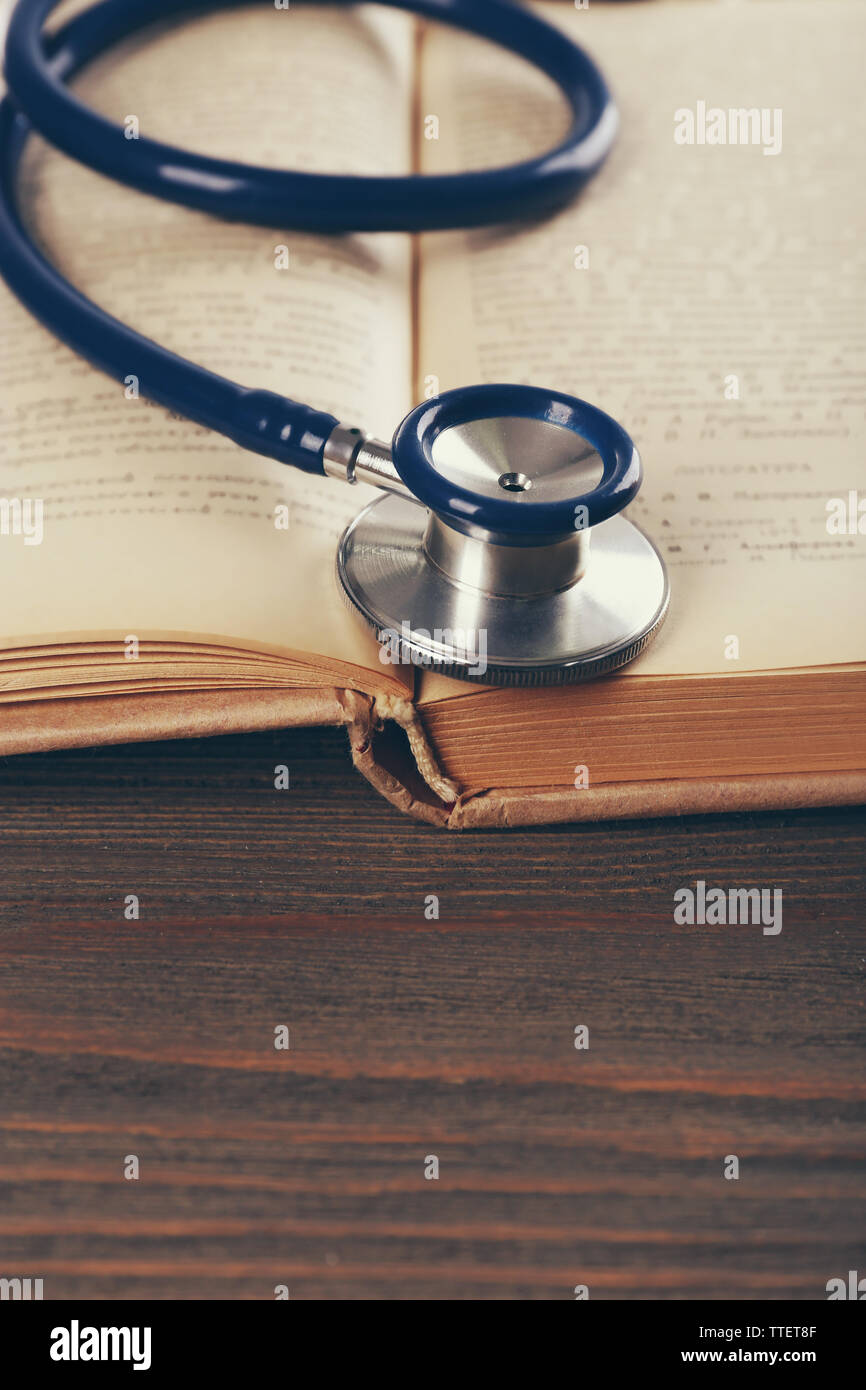 Book and stethoscope on wooden table closeup Stock Photo - Alamy