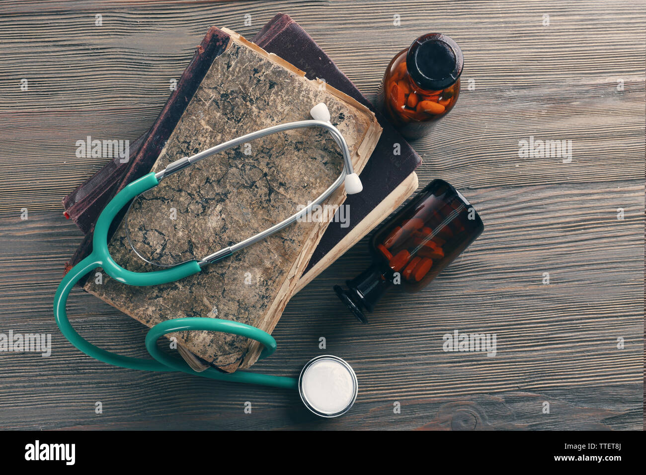 Books, pills and stethoscope on wooden table, top view Stock Photo - Alamy
