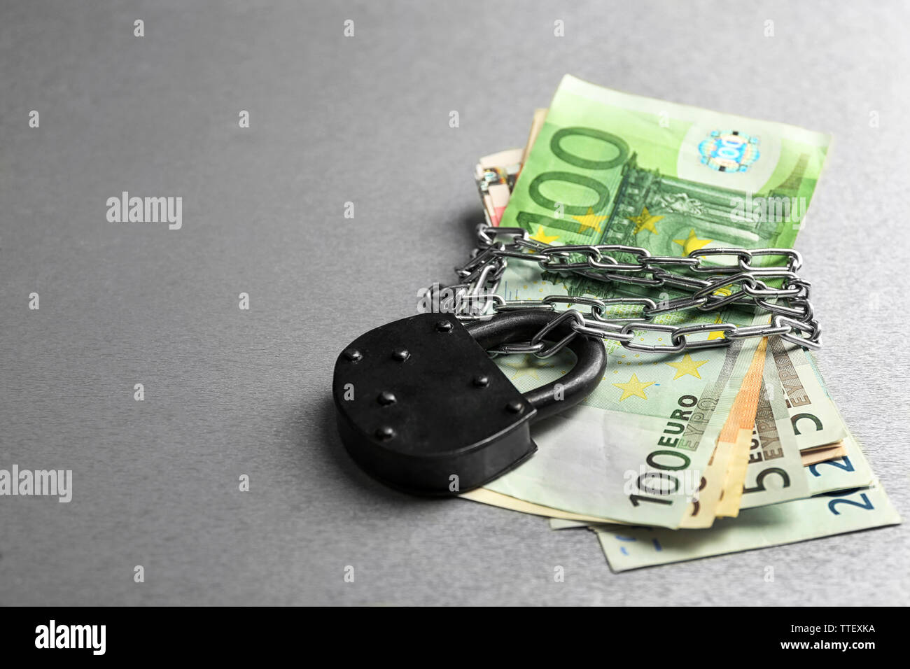 Euro banknotes with lock and chain on gray background Stock Photo - Alamy