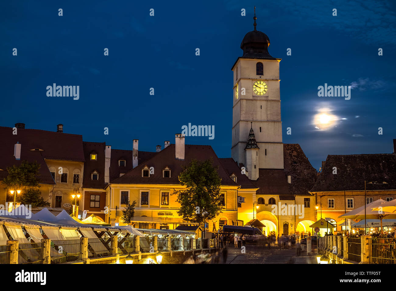 Sibiu City, Romania - 16 June 2019. Twilight image of Council Tower with moon and Small Square (Piata Mica) landmark of Sibiu town in Transylvania Rom Stock Photo