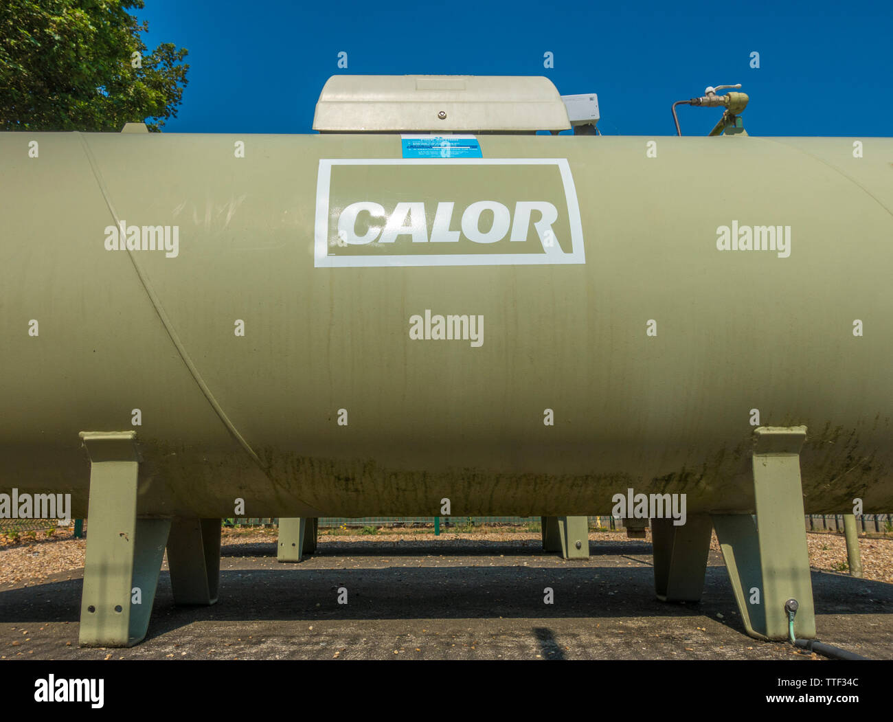 A large above ground Calor Gas LPG propane tank, being used as a fuel supply by a campsite, standing against a blue sky. England, UK. Stock Photo