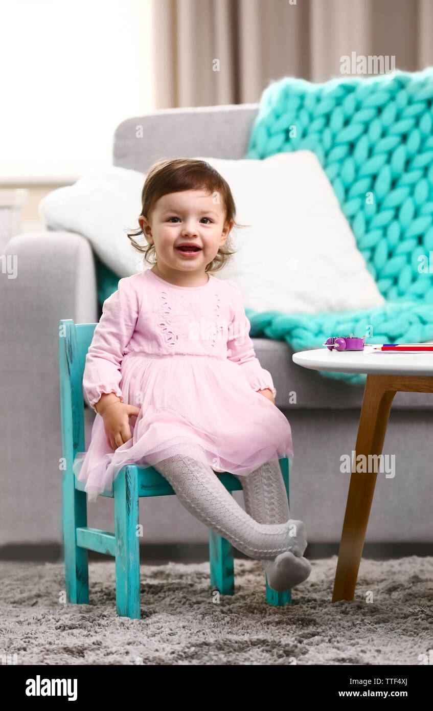 Little girl sitting on the chair in the room Stock Photo - Alamy