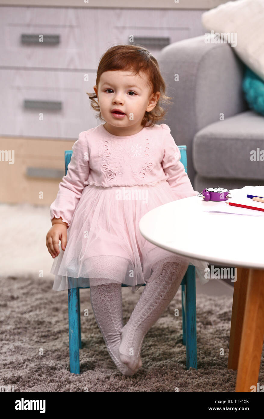 Little girl sitting on the chair in the room Stock Photo - Alamy