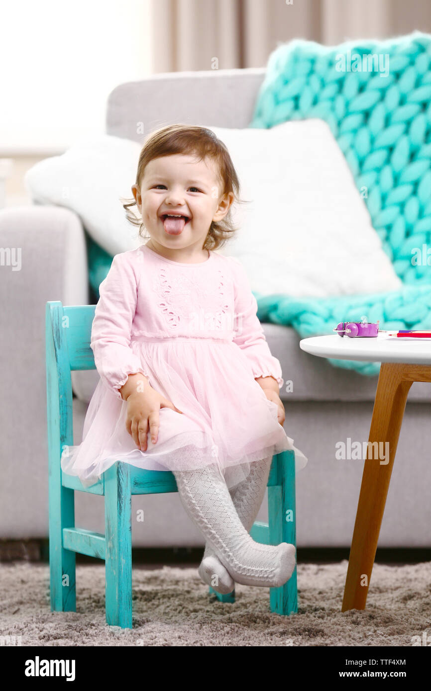 Little girl sitting on the chair in the room Stock Photo - Alamy