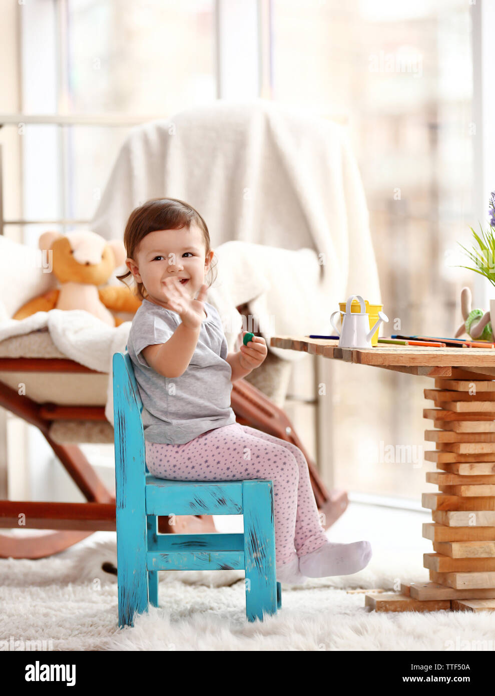 Little girl playing with toys in the room Stock Photo - Alamy