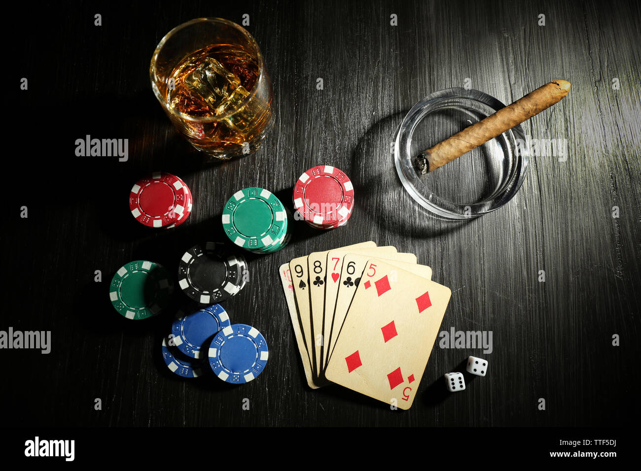 Set to playing poker with cards and chips on wooden table, top view
