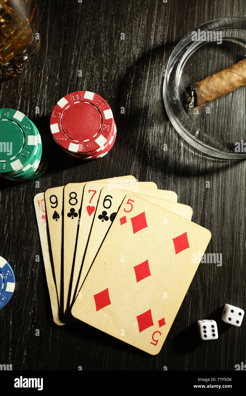 Set to playing poker with cards and chips on wooden table, top view