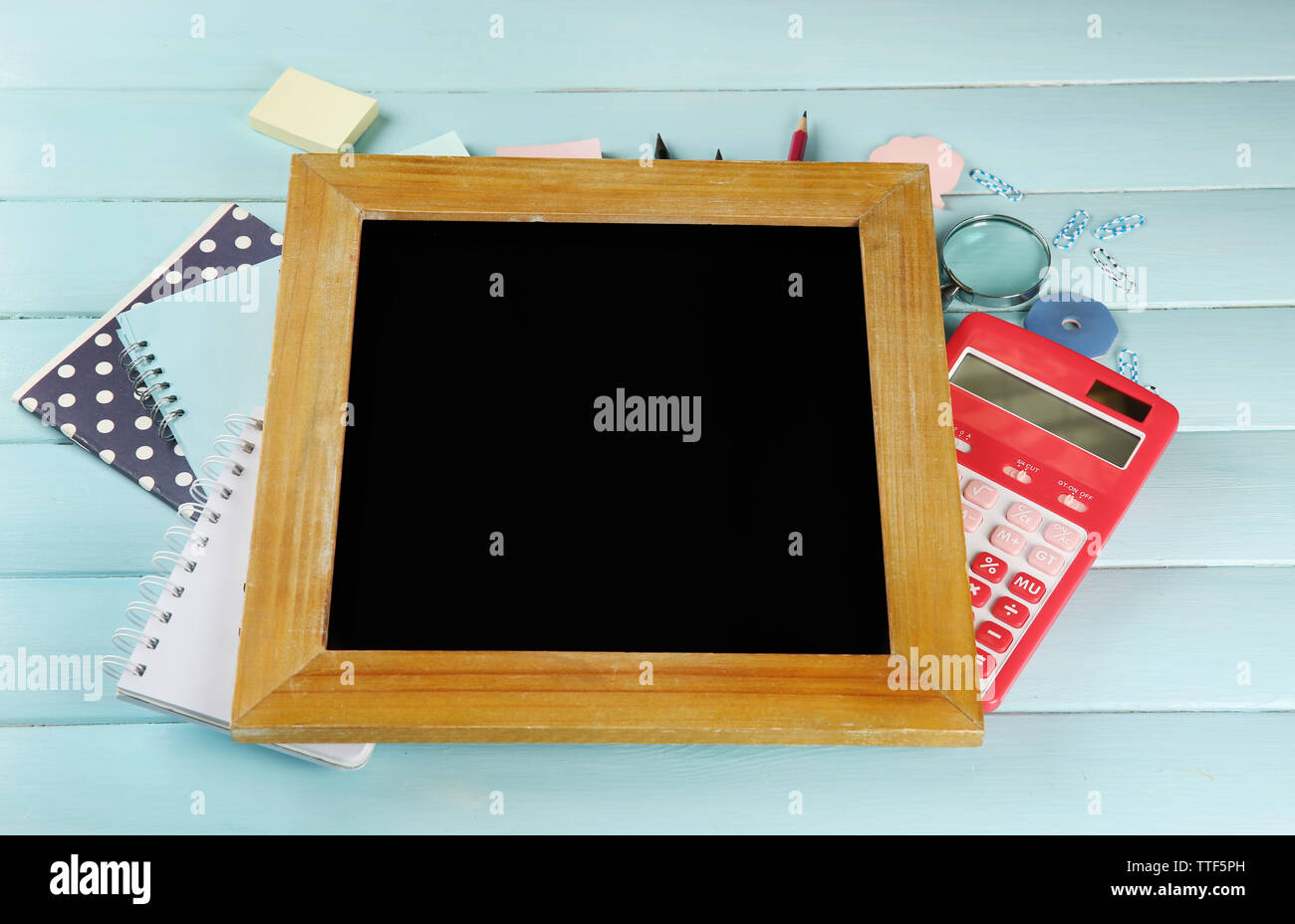 Small school blackboard with stationery on wooden background Stock Photo