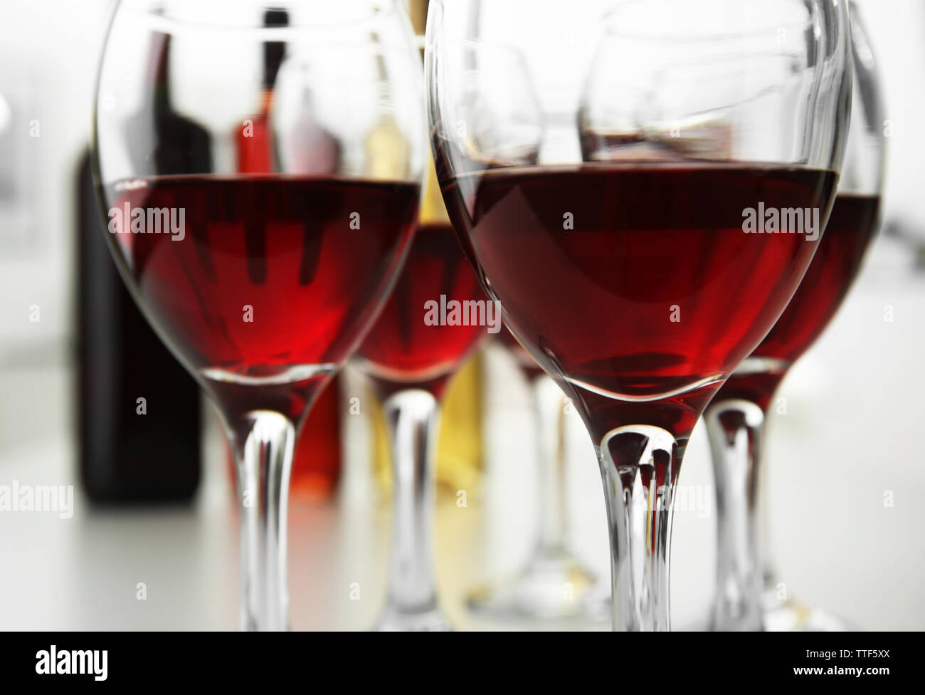 Glasses of red wine on white table closeup Stock Photo - Alamy